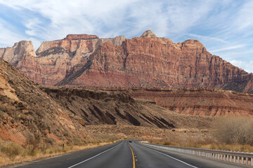 Single car alone on curving road driving toward a mountain adventure vacation getaway