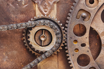 Rusty gears and chain closeup. Vintage industrial mechanism with corroded metal components. Aged cogwheels and machinery detail in macro view.