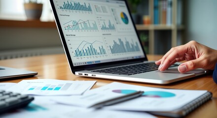 Businesswoman working on laptop with financial reports. Analyzing data, statistics for growth, profit. Office environment. Financial analysis in progress. Performance indicators displayed on screen.