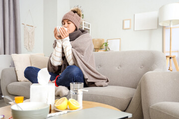 Sick young woman drinking hot tea at  home
