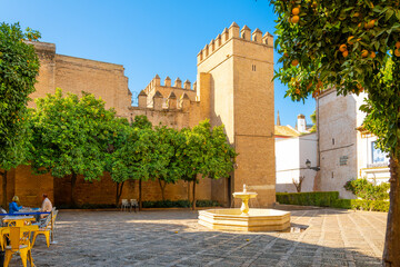 The Plaza de la Alianza at the Royal Alcazar, Taifa Gate and Blue Tile of Christ of Mercy, in the Barrio Santa Cruz district of the Andalusian city of Seville, Spain.