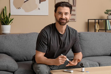 Diabetic man using lancet pen at home
