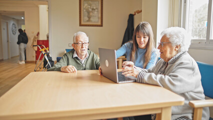 young girl teaching how to use a laptop computer to her grandparents
