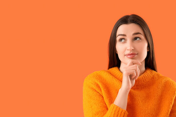 Wondering young woman on orange background, closeup