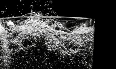 Decorative images of close-up soda water bubbles fizzing up or splashing or sparkling like a bomb exploding on black background