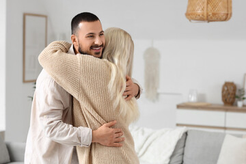 Young man hugging his mother at home