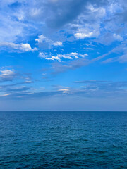 Fototapeta premium Blue Mediterranean quiet sea water horizon over a blue cloudy sky