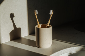 Two wooden toothbrushes in a glass near the sink. Concept: cohabitation, couple in love, family. 