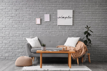 Interior of living room with grey sofa, table and pouf