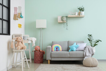 Interior of nursery with changing table, sofa and toys
