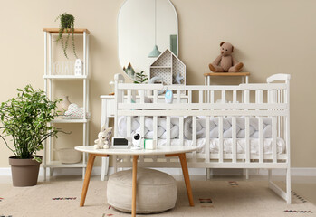 Interior of children's bedroom with crib, shelf unit and baby monitor on table