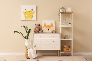 Interior of nursery with commode, shelf unit and pictures