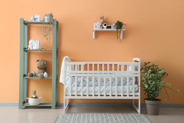 Interior of children's bedroom with crib and baby monitor on shelf