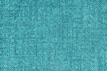 Upholstery turquoise colored jacquard fabric coarse weave texture close up, macro. Textile...