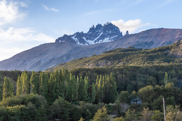 vista a los cuernos de Cerro Castillo al amanecer, ambiente de bosque y cielo azul con algunas nubes, Aysén, Patagonia, Chile