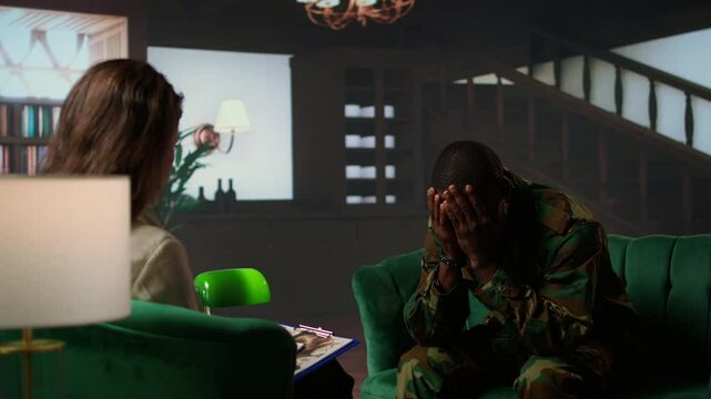 Distraught soldier in tears sharing his struggles with war PTSD, attends therapy session with expert for rehabilitation. Psychological support and society reintegration for veterans. Camera A.