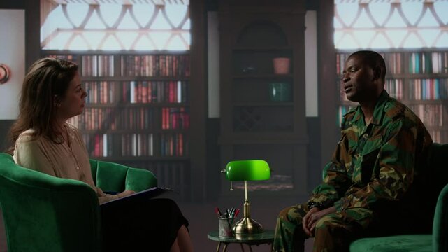 African american soldier looks distressed during a counseling session for trauma recovery, trying to open up and share his grief. PTSD support and mental health treatment for combatant. Camera A.