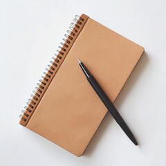 Tan spiral notebook and black pen on white background.