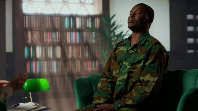 Woman therapist helping war veteran with exercises to treat traumatic depression, soldier opening up about horror combat scenes lived by his company. Psychotherapy session with counselor. Camera B.