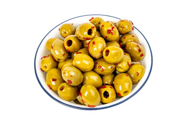 Top down view of a white bowl of spicy whole green Manzanillo olive with bits of red pepper isolated on white