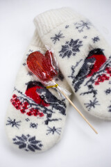Women's woolen mittens with a mug of hot drink and marshmallows. Winter