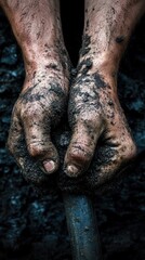 Dirty hands gripping a metal tool in soil.