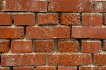 Close-up texture of old red brick wall with weathered surface and visible mortar seams, showcasing industrial charm and timeless architectural details. Perfect for backgrounds and design concepts