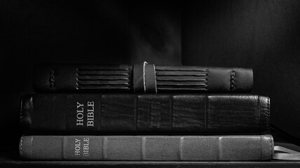 Black and White Stacked Leather Bibles in Dramatic Light
