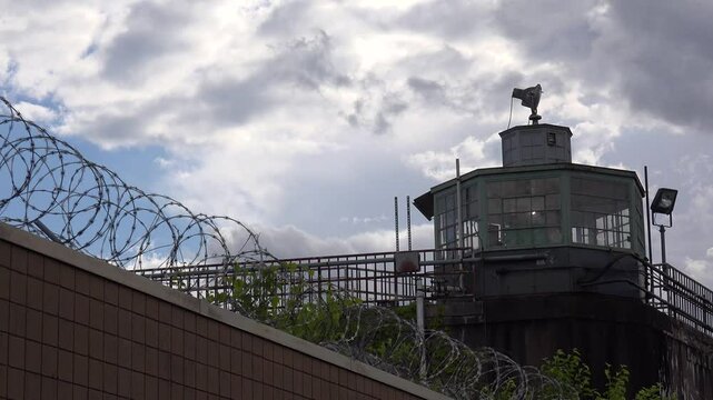 PITTSBURGH - 7.11.2024 - Excellent low-angle close-up timelapse of barbed wire fencing and a guard tower at the Pittsburgh Western Penitentiary.