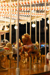 winter carousel at a Christmas village with bright lights. © Dmitriy