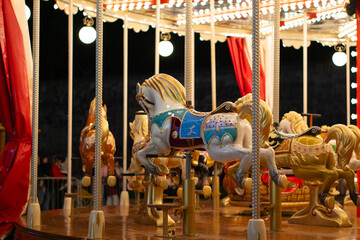 winter carousel at a Christmas village with bright lights.