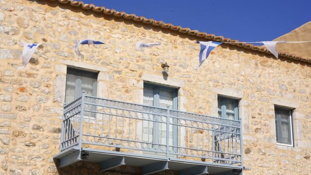 Stone house in Areopoli with flags of Greece and Flag of the fighters of the autonomous Mani Peninsula