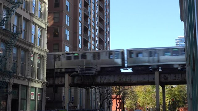 CHICAGO - 12.5.2024 - An elevated train exits a passage between apartment buildings in Chicago.