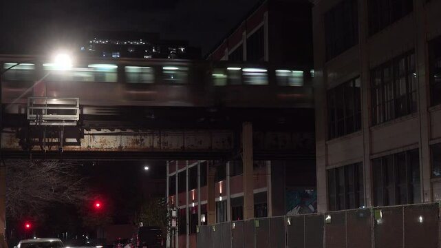 CHICAGO - 12.5.2024 - Close-up of an elevated train entering a passage between apartment buildings in Chicago at night.