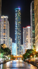 Fototapeta premium Night Cityscape, Illuminated Skyscrapers Reflecting on Calm Water, City Lights Glimmering on River, Urban Night Scene