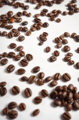 Obraz premium Close-up of Roasted Coffee Beans Scattered on White Surface