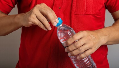Hands opening a plastic water bottle, with a red shirt.