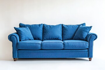 A cozy blue three seater sofa rests on a white backdrop isolated against a white wall