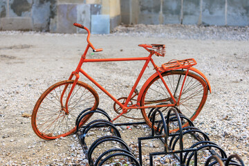 Obraz premium An old, rusty bicycle is sitting on top of a rack of bicycles, bicycle parking