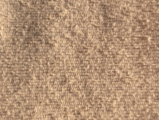 Close-up macro view of beige textured sofa cover with woven pattern. Detailed fibers cozy fabric texture background in natural tone. Home decor, material quality sample, interior design concept.