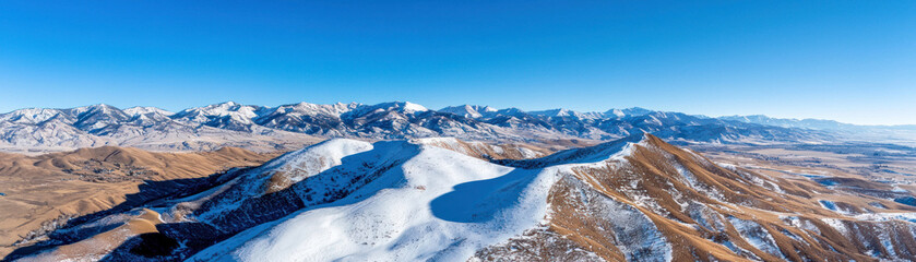breathtaking birds eye view of snowy mountain range under clear blue sky, showcasing beauty of nature