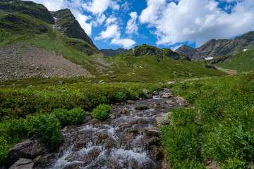 The valley of the Malaya Dukka River on the slopes of the Arkasar ridge in the North Caucasus and the tourist trail to the Dukka Lakes on a sunny summer day, Arkhyz, Karachay-Cherkessia, Russia © Ula Ulachka