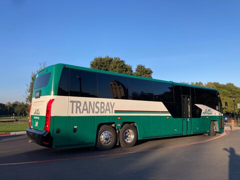 MCI D45 CRT LE transit coach bus in green and white colors operated by AC Transit. Side rear view - Palo Alto, California, USA - December 19, 2024