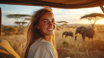 Happy woman on safari viewing elephants at sunset.