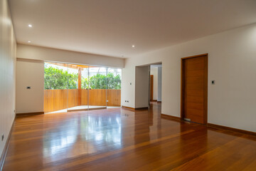 Sala de departamento con piso de melamina, con mampara y vista a patio iluminado