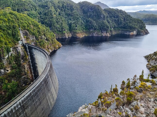 Gordon Dam in Tasmania, an impressive concrete structure surrounded by rugged cliffs and a lake in...