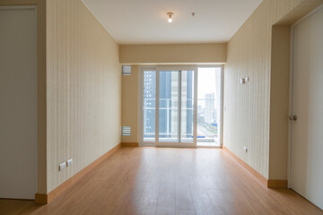 Vista de sala de departamento con amplia mampara con vista a la calle , con acabados modernosm, piso de madera y paredes blancas 