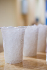 Plastic cup filled with crushed ice on a table.