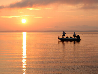 Early Fishermen in Boat on Lake at Sunrise