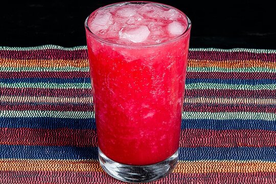 A traditional iftar drink like Rooh Afza or tamarind juice in a tall glass, placed on a colorful tablecloth